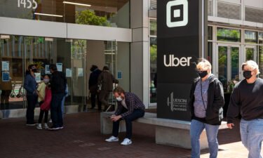 People wear protective masks in front of Uber's headquarters in San Francisco