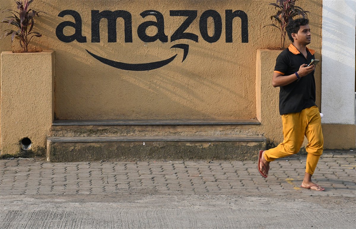 <i>Ashish Vaishnav/SOPA Images/LightRocket/Getty Images</i><br/>Amazon has stopped selling devices that can disable seatbelt alarms in India following a request from the government. A man walks past an Amazon warehouse in India in October of 2021.
