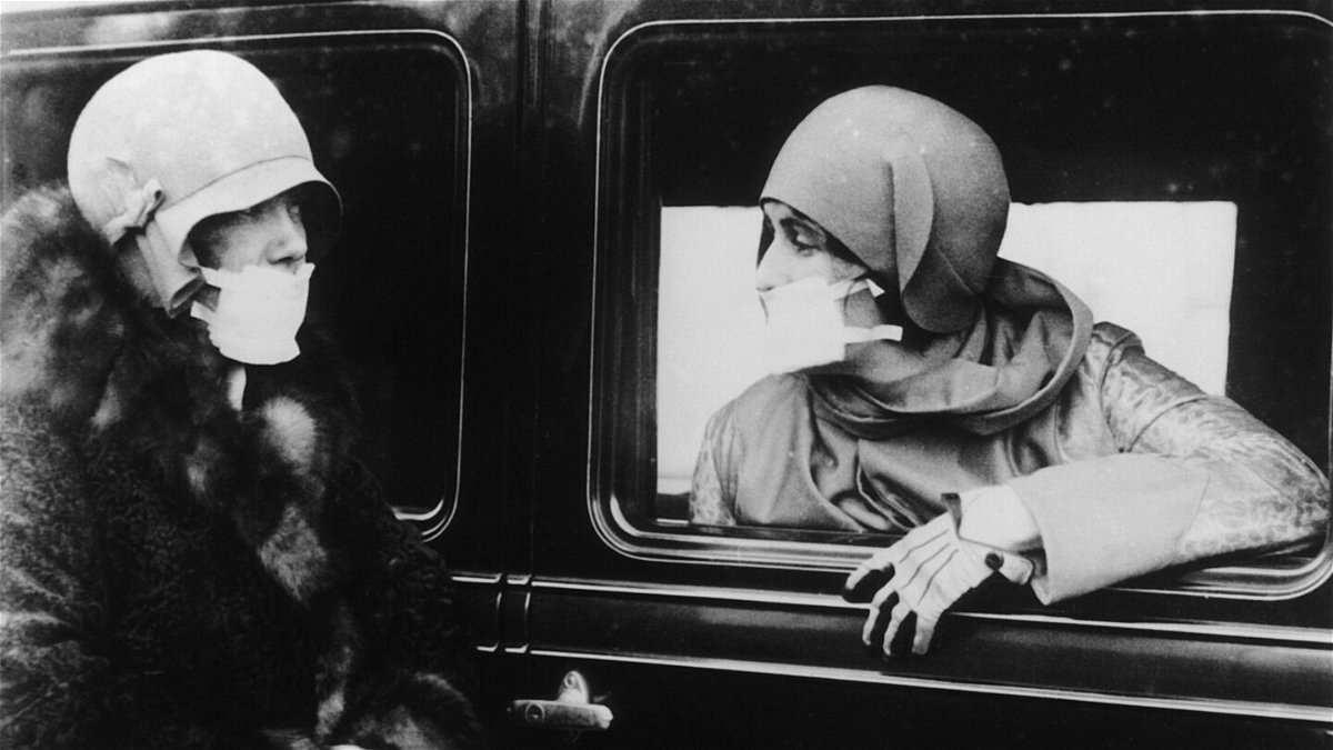 <i>Keystone/Hulton Archive/Getty Images</i><br/>Two women are seen wearing flu masks during a flu epidemic in 1929.