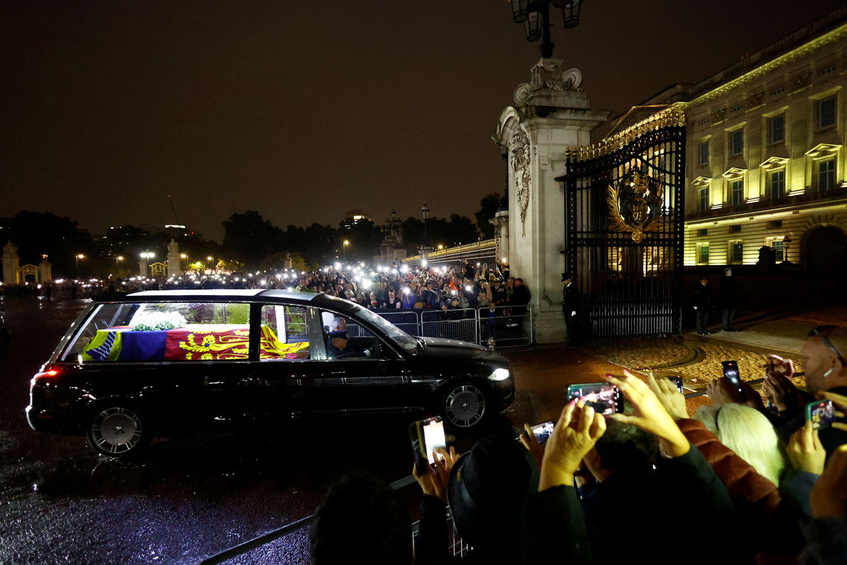 <i>Andrew Boyers/Reuters</i><br/>People watch the arrival of the hearse carrying the coffin of Britain's Queen Elizabeth II in London on September 13.