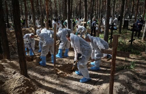 Members of the Ukrainian Emergency Service work at a mass burial site during an exhumation