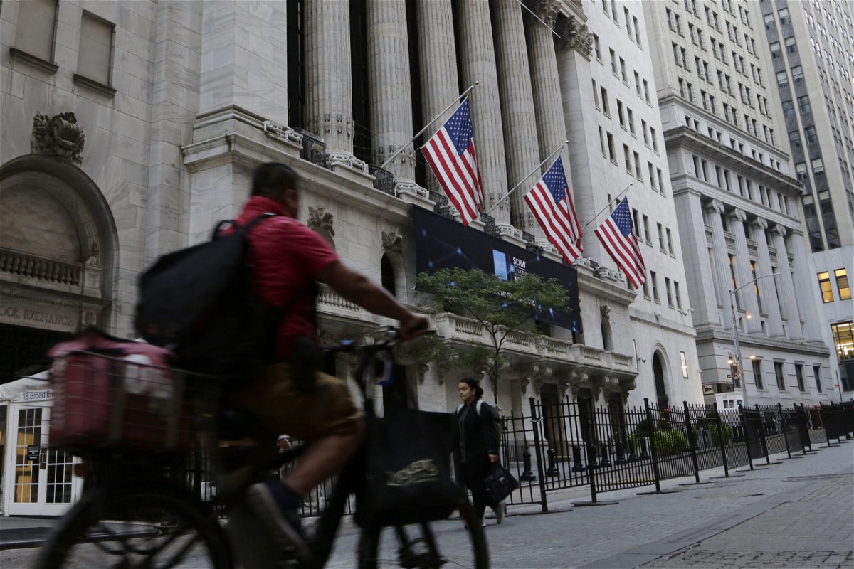 <i>Peter Morgan/AP</i><br/>US stock futures were set to fall sharply as investors continued to worry about even more rate hikes from the Federal Reserve that could land the US economy in a recession. A man is pictured here riding a bike in front of the New York Stock Exchange on September 21.