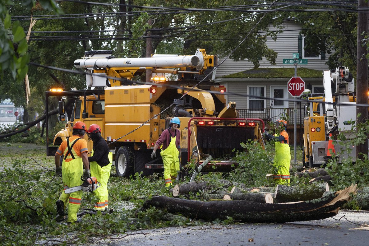 <i>Darren Calabrese/AP</i><br/>Workers clear fallen trees and downed wires from damage caused by post tropical storm Fiona in Halifax on Saturday.