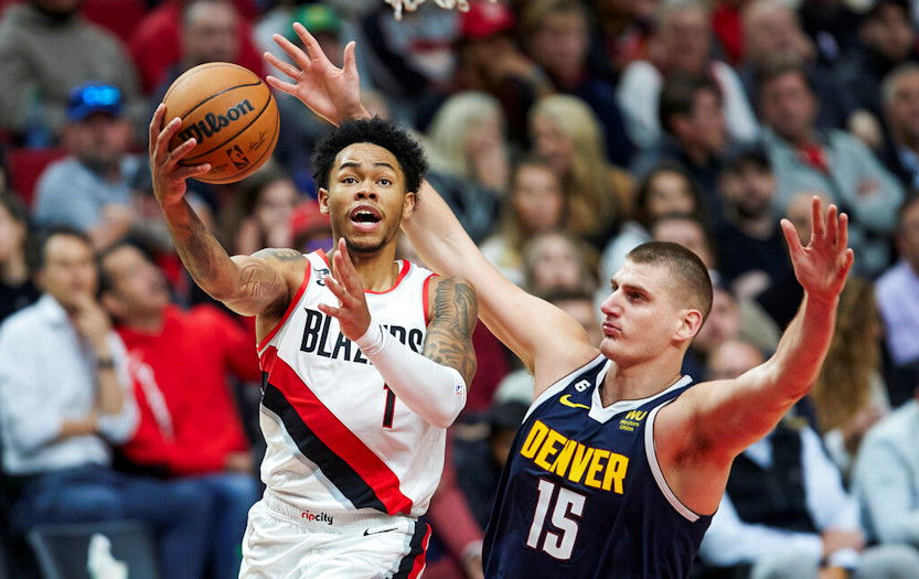 Portland Trail Blazers guard Anfernee Simons, left, shoots over Denver Nuggets center Nikola Jokic during the second half of Monday night's game in Portland