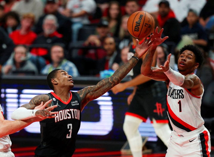 Houston Rockets guard Kevin Porter Jr., left, and Portland Trail Blazers guard Anfernee Simons, right, reach for a rebound during the first quarter of Friday night's game in Portland