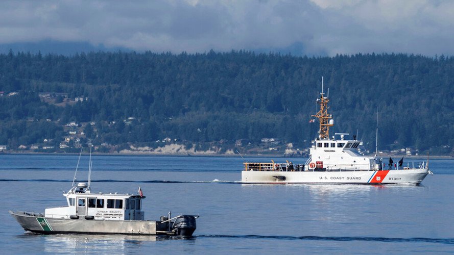 A U.S. Coast Guard boat and Kitsap, Wash., County Sheriff's Office boat search the area near Freeland, Wash., on Whidbey Island north of Seattle on Sept 5, where a chartered floatplane crashed the day before, killing 10 people.