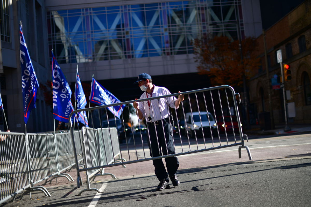 <i>Mark Makela/Getty Images</i><br/>A security guard sets up a barricade in front of a designated demonstration area for supporters of President Donald Trump outside of where votes were still being counted