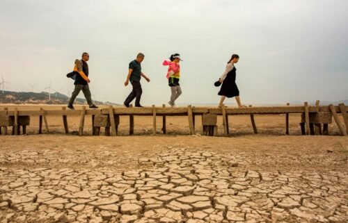 Tourists walk on an ancient bridge which emerged from dried Poyang Lake on September 21