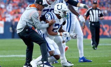 Indianapolis Colts running back Nyheim Hines is helped to his feet after being hit during a game against the Denver Broncos at Empower Field At Mile High on October 6 in Denver