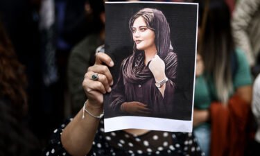 A protester holds a portrait of Mahsa Amini during a demonstration in her support in front of the Iranian embassy in Brussels on September 23.