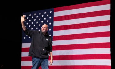 John Fetterman waves as he arrives onstage at a watch party during the midterm elections in Pittsburgh