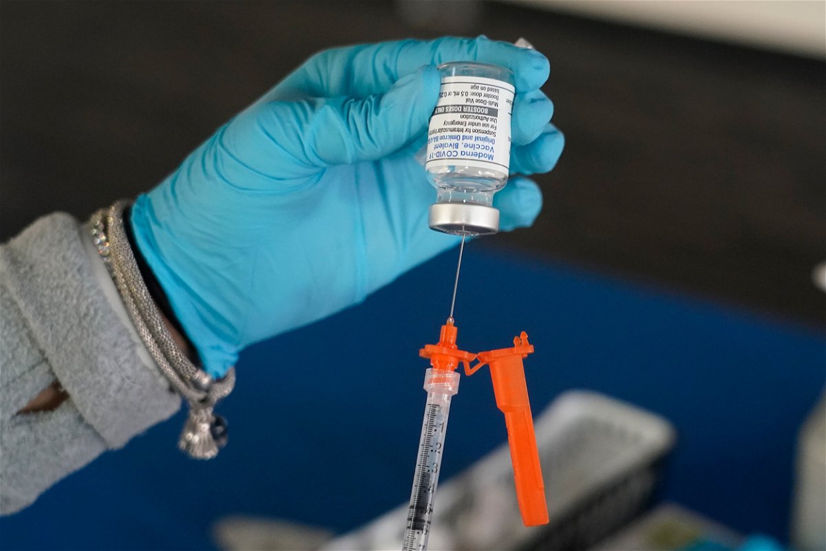 <i>Rogelio V. Solis/AP</i><br/>A nurse loads a syringe with a Moderna COVID-19 booster vaccine in Jackson