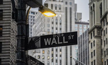 A street light brightens a Wall Street sign outside the New York Stock Exchange