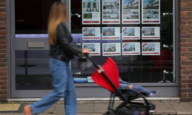 A member of the public looks at residential properties displayed for sale in the window of an estate agents' in London on September 30.
