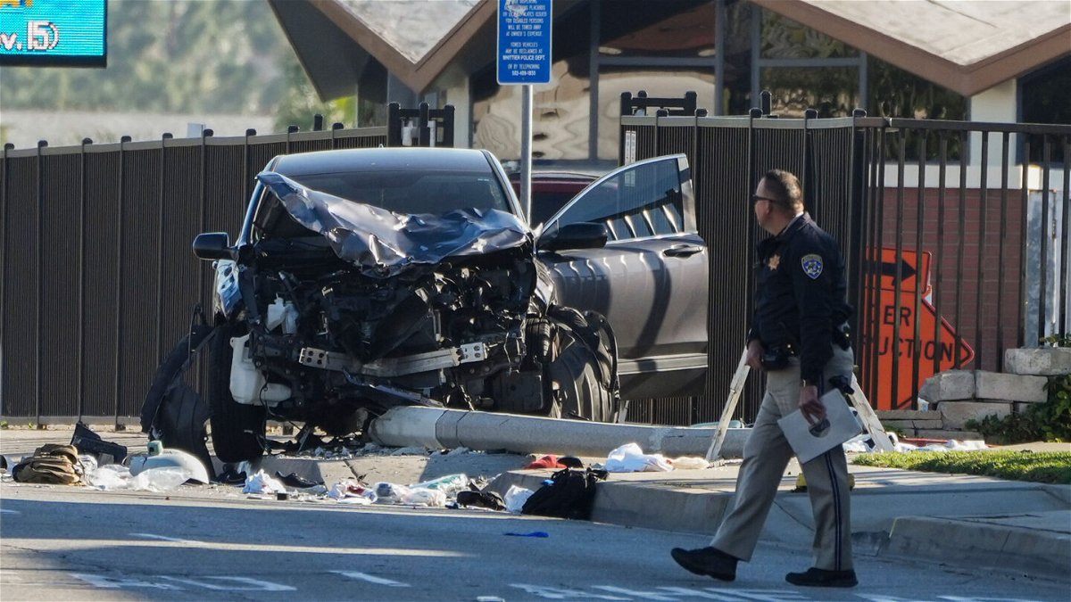 <i>Jae C. Hong/AP</i><br/>An investigator walks past a mangled SUV that struck Los Angeles County sheriff's recruits in Whittier