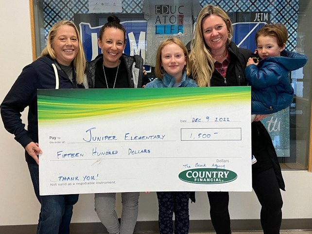 Allison Brock (second from right) with her children presenting donation to Juniper Elementary staff