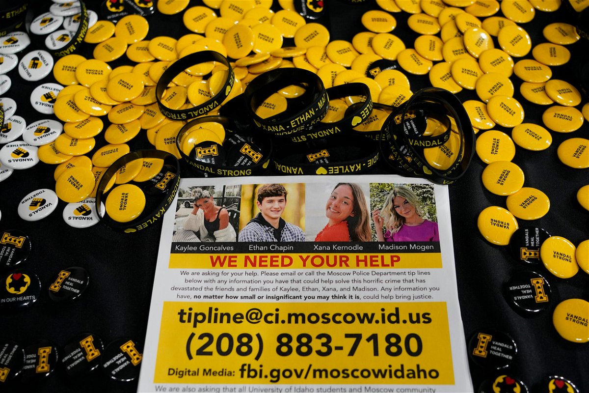 <i>Ted S. Warren/AP</i><br/>A flyer seeking information about the killings of four University of Idaho students is displayed on a table along with buttons and bracelets