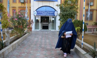 A female student walks in front of a university in Kandahar province