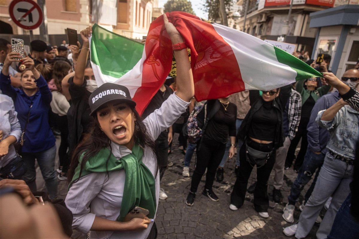 <i>Chris McGrath/Getty Images Europe/Getty Images</i><br/>People hold signs and chant slogans during a protest over the death of Iranian Mahsa Amini outside the Iranian Consulate on September 21