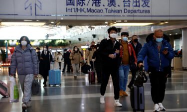 Travelers walk with their luggage at Beijing Capital International Airport