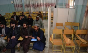 Male students attend a class behind a curtain meant to separate men from women at a university in Kandahar province