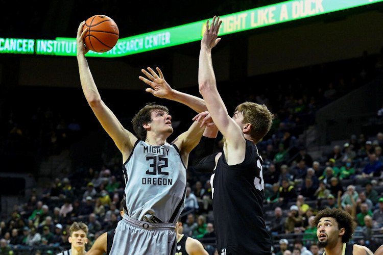 Oregon center Nate Bittle (32) shoots over Colorado center Lawson Lovering, center right, during the first half of Thursday's game in Eugene