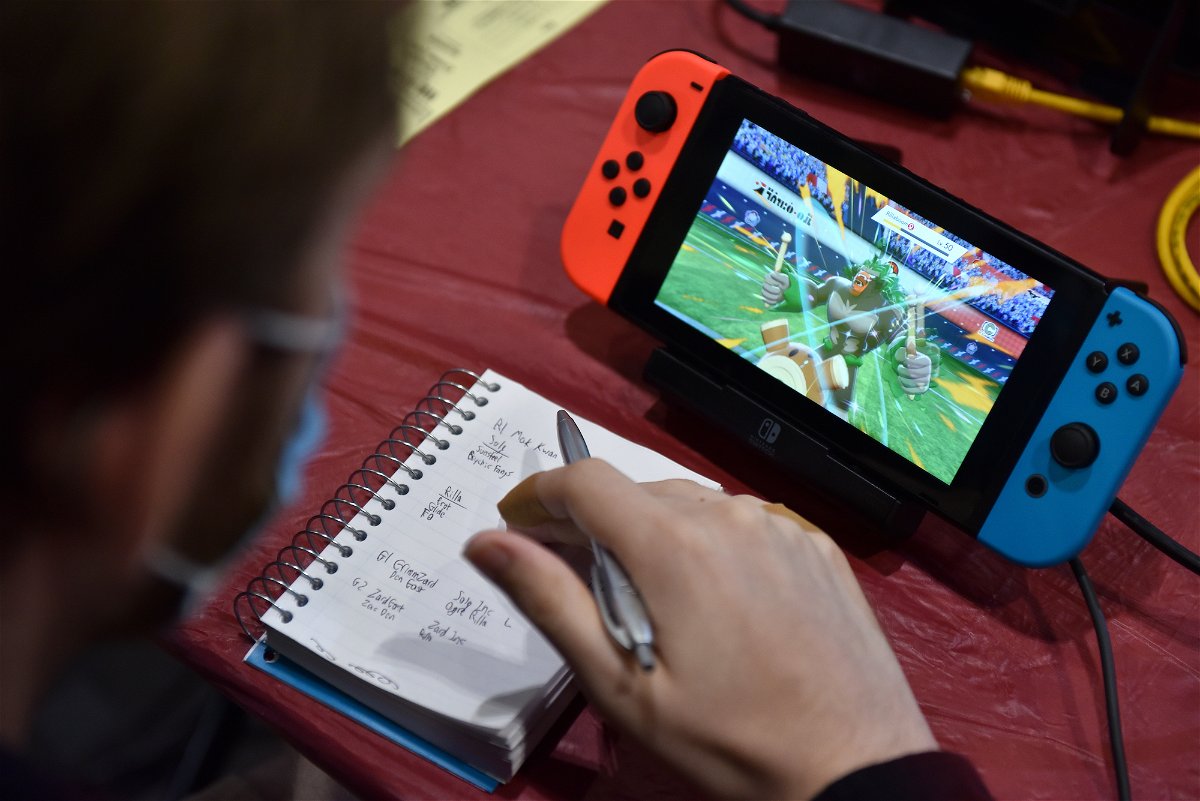 <i>John Keeble/Getty Images/FILE</i><br/>A competitor makes notes while playing Pokemon on a Nintendo Switch console during the 2022 Pokémon World Championships on August 18