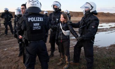 Police officers detain climate activist Greta Thunberg in Germany on Tuesday.