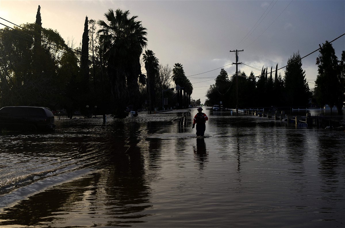 <i>Josh Edelson/AFP/Getty Images</i><br/>A San Diego firefighter wades through floodwaters in Merced