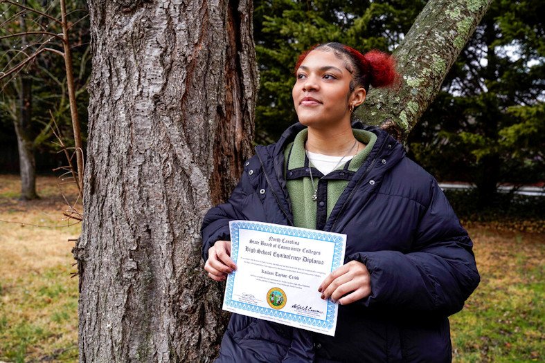 Kailani Taylor-Cribb holds her GED diploma outside her home in Asheville, N.C., on Tuesday, Jan. 31, 2023. She is among hundreds of thousands of students around the country who vanished from public school rolls during the pandemic and didn’t resume studies elsewhere