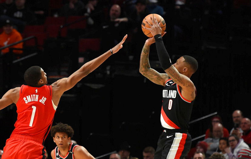 Portland Trail Blazers guard Damian Lillard, right, hits a basket over Houston Rockets forward Jabari Smith Jr., left, during the first half of Sunday night's NBA contest