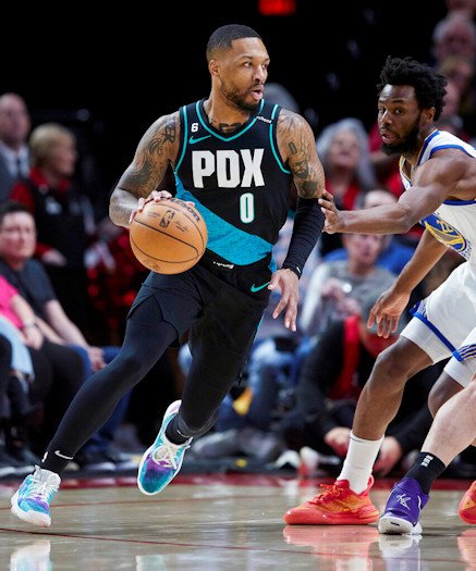 Portland Trail Blazers guard Damian Lillard, left, dribbles around Golden State Warriors forward Andrew Wiggins during the first half of Wednesday night's game in Portland
