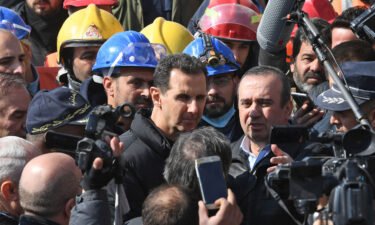 Syrian President Bashar al-Assad (center) visits neighborhoods affected by an earthquake in the northern city of Aleppo