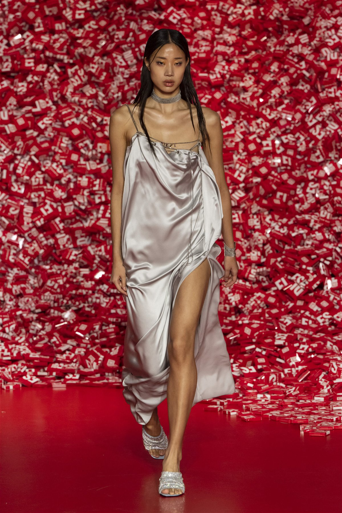 <i>Victor Virgile/Gamma-Rapho/Getty Images</i><br/>A model wearing a silk dress with draped chains on the runway.