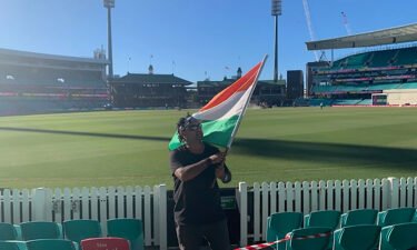 Krishna Kumar waves the Indian flag during the test match between Australia and India.