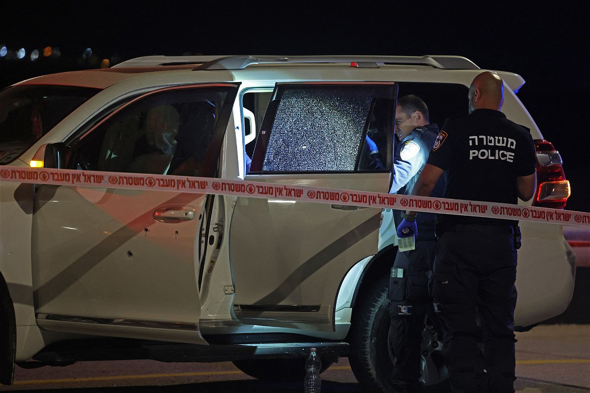 <i>Ahmad Gharabli/AFP/Getty Images</i><br/>Israeli security forces examine a vehicle riddled with bullet holes
