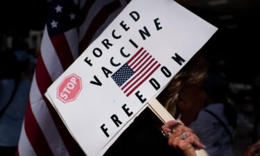 Anti-vaccine rally protesters hold signs outside of Houston Methodist Hospital in Houston