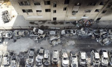 An aerial view shows a building and cars burnt in an attack by Israeli settlers