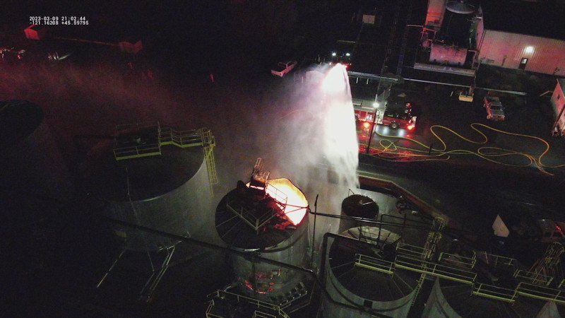Crews pour water on burning tank after explosion at AmeriTies West railroad tie treatment plant in The Dalles Thursday night