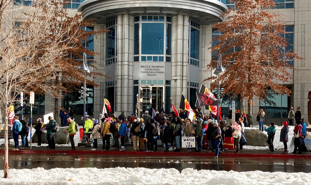 Dozens of tribe members and other protesters beating drums and waving signs rally in front of the federal courthouse in Reno, Nev. Thursday, Jan. 5, 2023, as a court hearing began over a lawsuit seeking to block a huge lithium mine planned near the Nevada-Oregon line about 200 miles north of Reno