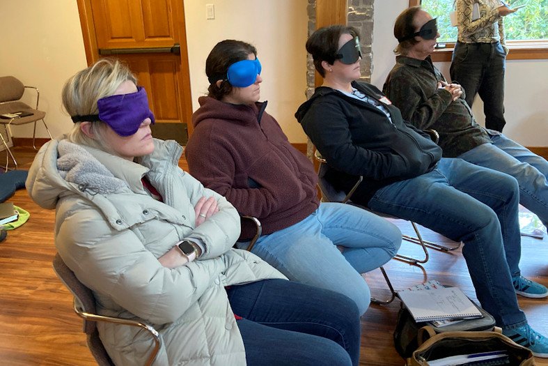 Psilocybin facilitator students sit with eye masks on while listening to music during an experiential activity at a training session run by InnerTrek near Damascus, Ore., on Dec. 2, 2022