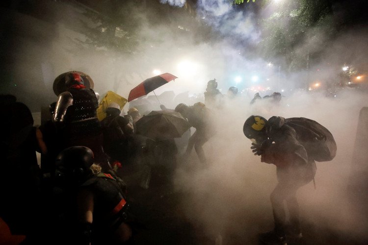 Federal officers launch tear gas at a group of demonstrators during a Black Lives Matter protest at the Mark O. Hatfield United States Courthouse in Portland, Ore., on July 26, 2020