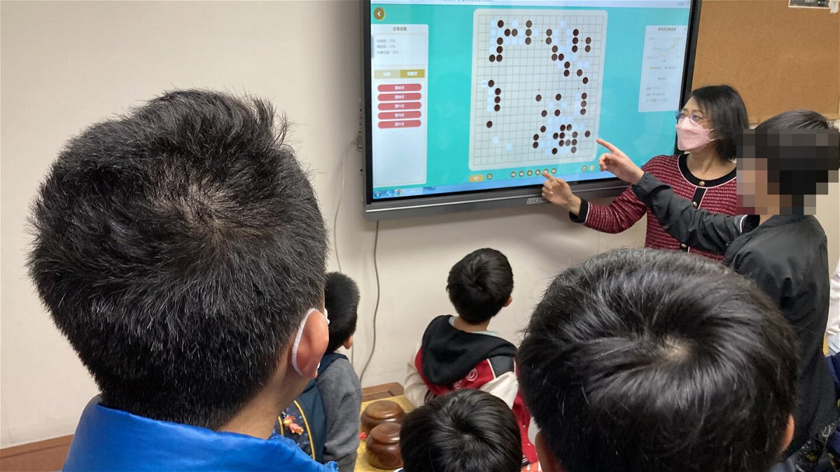 <i>Courtesy Hong Kong Children's Go College</i><br/>Ao Lixian and her students discuss strategy at Hong Kong Children's Go College (CNN blurred portions of the image to protect a child's identity).