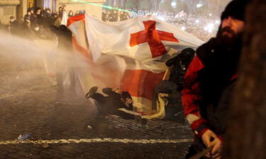 Police use a water cannon to disperse protesters.