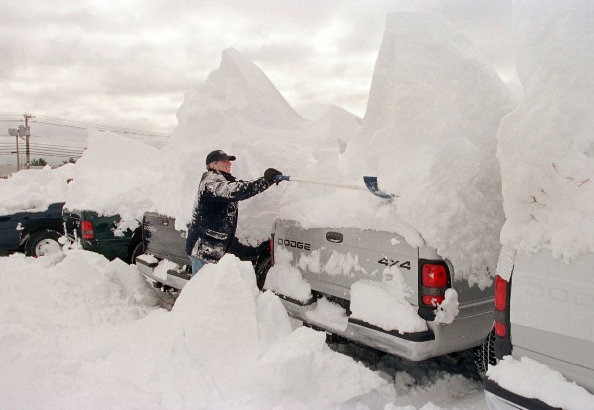 <i>Joel Page/AP/FILE</i><br/>A man clears snow off vehicles after a major nor'easter in 2001 dumped snow across the Northeast.