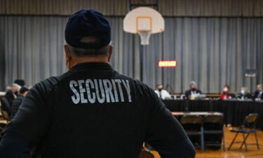 A Pennsbury School District security guard observes a Pennsbury School Board meeting in Levittown