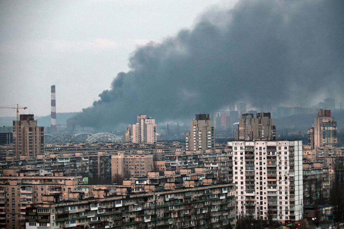 <i>Eugen Kotenko/Ukrinform/Future Publishing/Getty Images</i><br/>A plume of smoke rises above an infrastructure facility in the Holosiivskyi district during Russia's mass missile attack on Ukraine