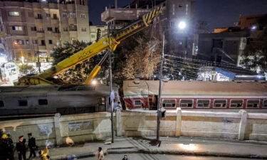 A crane is deployed to lift a derailed train at the scene of a railroad accident in the city of Qalyub in Qalyub province