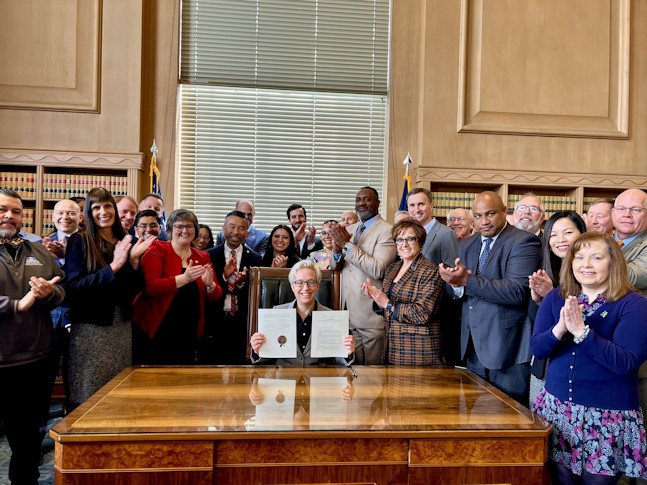 Gov. Tina Kotek holds up Oregon Chips Act bill at signing ceremony