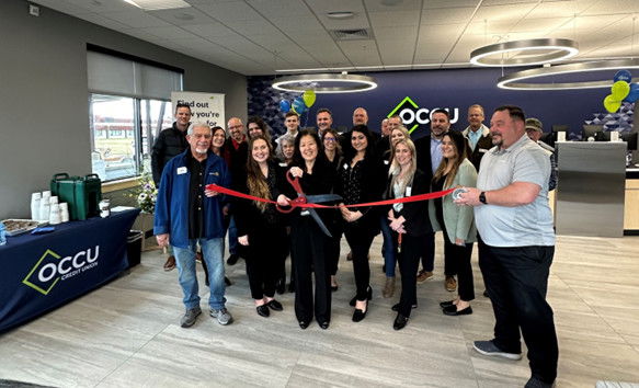 OCCU Regional Branch Manager Sharon Calhoun (center) cuts a ribbon to officially open the Redmond branch, alongside OCCU team members, local business leaders and representatives of Redmond’s Chamber of Commerce